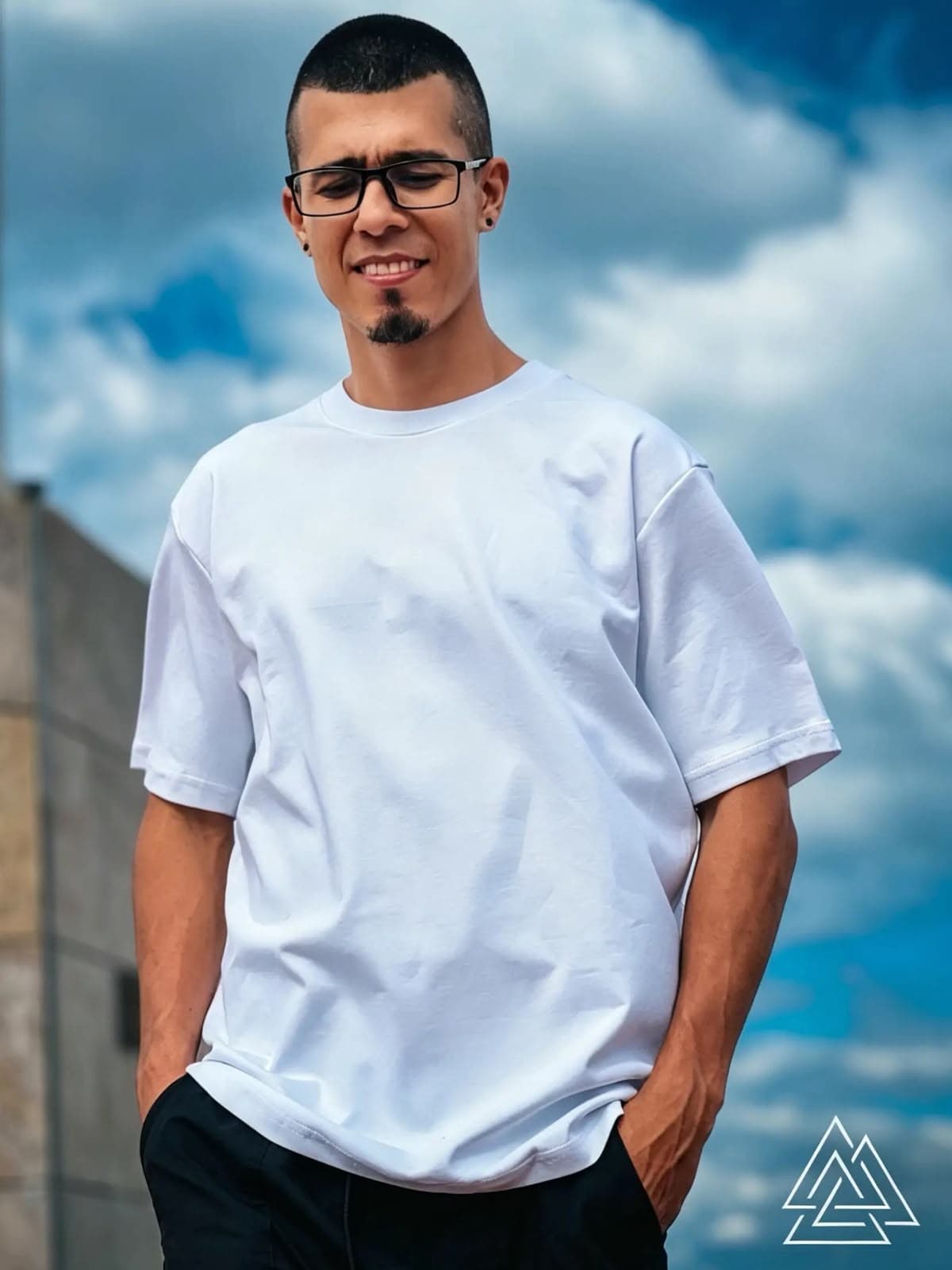 Modelo real usando camiseta oversize Valknut blanca, con el símbolo valknut de marca